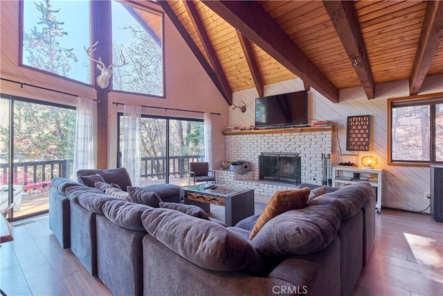 living area with a brick fireplace, wooden walls, and a wealth of natural light