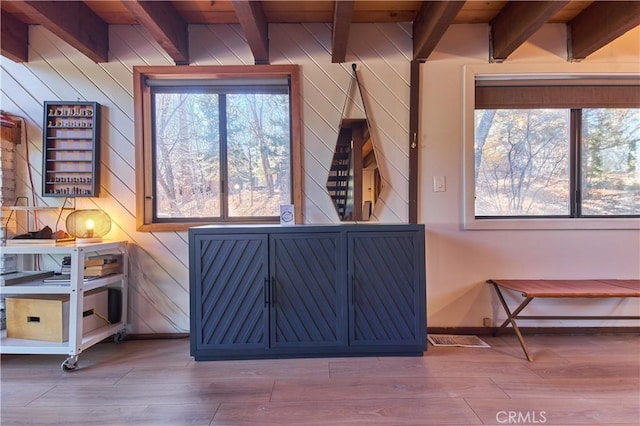 sitting room featuring a healthy amount of sunlight, beamed ceiling, and wood finished floors