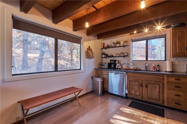 bar featuring a sink, dark wood-style flooring, backsplash, and stainless steel dishwasher