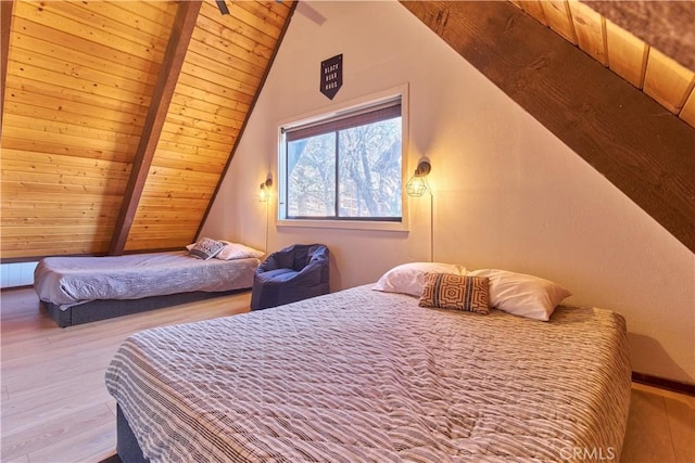 bedroom with vaulted ceiling with beams, wooden ceiling, and wood finished floors