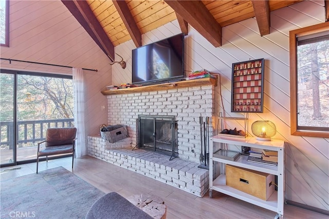 interior space featuring wooden ceiling, a fireplace, vaulted ceiling with beams, and wooden walls