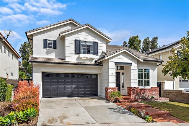 view of front of property with a tile roof, stucco siding, concrete driveway, fence, and a garage