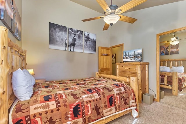 bedroom featuring a ceiling fan, carpet flooring, and a high ceiling