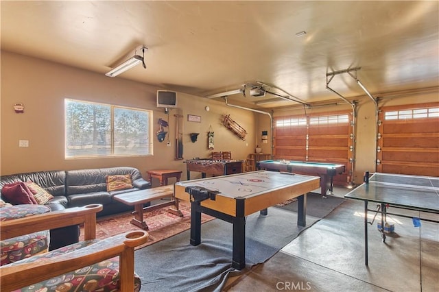 recreation room with a garage and finished concrete floors