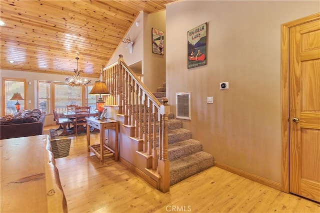 staircase with wood ceiling, wood finished floors, visible vents, and a notable chandelier