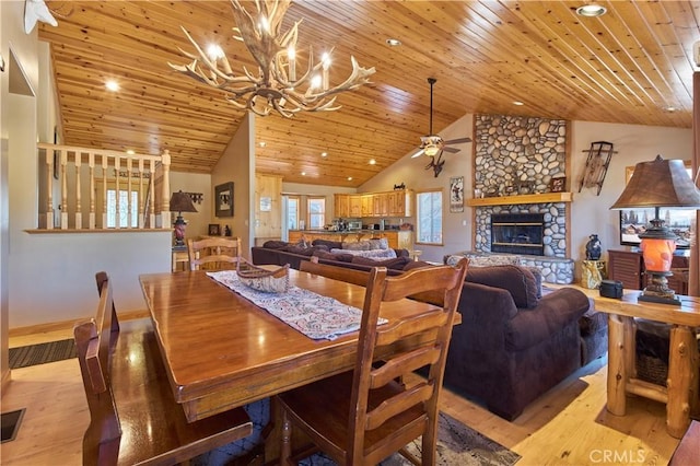 dining space featuring wooden ceiling, a fireplace, and light wood-style flooring