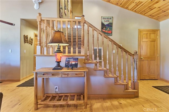 stairs featuring wood ceiling, vaulted ceiling, baseboards, and wood finished floors