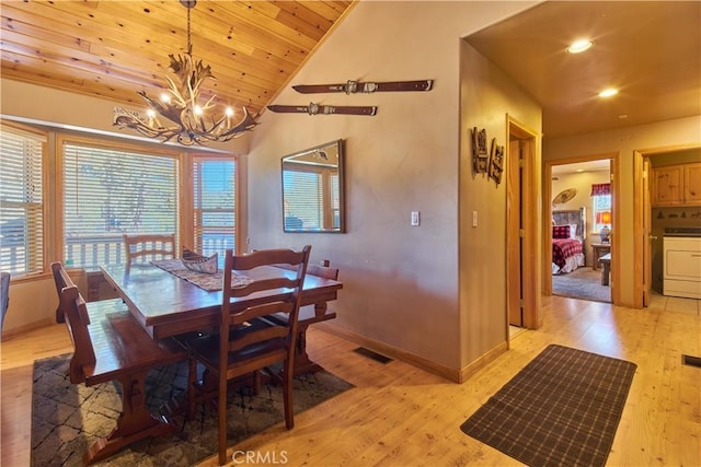 dining area featuring visible vents, washer / clothes dryer, light wood-style flooring, and an inviting chandelier