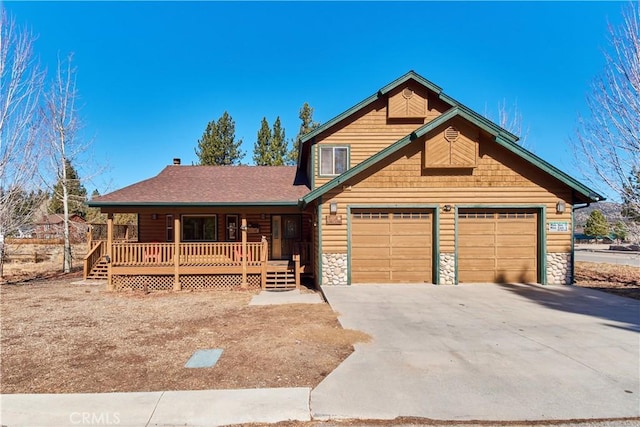 view of front of house with a porch, an attached garage, driveway, stone siding, and roof with shingles