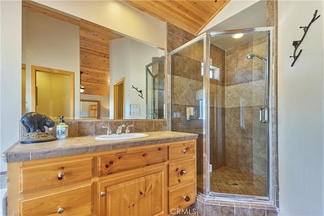 full bathroom with vaulted ceiling, vanity, a shower stall, and wood ceiling