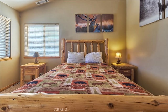 bedroom featuring lofted ceiling and visible vents