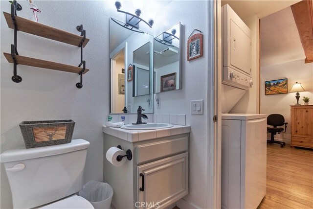 half bathroom with toilet, wood finished floors, and vanity