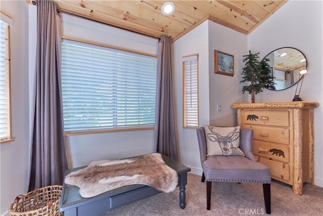 sitting room with vaulted ceiling, carpet floors, and wood ceiling