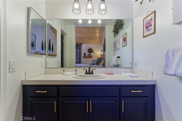 bathroom with wood ceiling, vanity, and ensuite bathroom