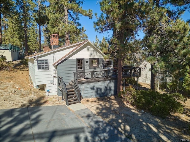 view of front of house featuring a garage, driveway, and a chimney