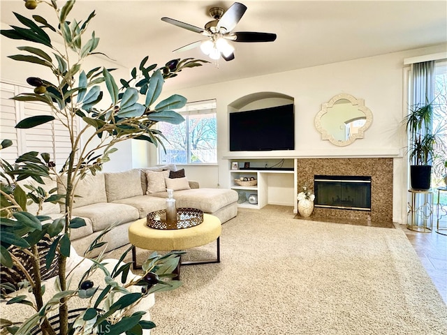 living room featuring ceiling fan and a fireplace