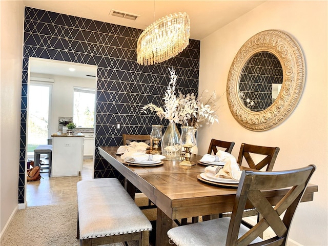 dining room featuring visible vents, a notable chandelier, tile walls, and light tile patterned floors