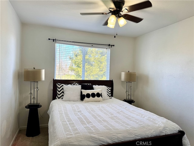 carpeted bedroom with ceiling fan and baseboards