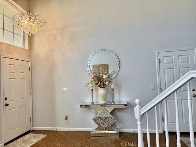 entryway with an inviting chandelier, baseboards, stairway, and tile patterned flooring