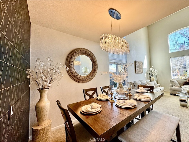 dining space featuring baseboards, carpet, and a notable chandelier