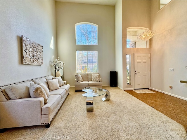 living area with tile patterned flooring, a high ceiling, carpet, and baseboards