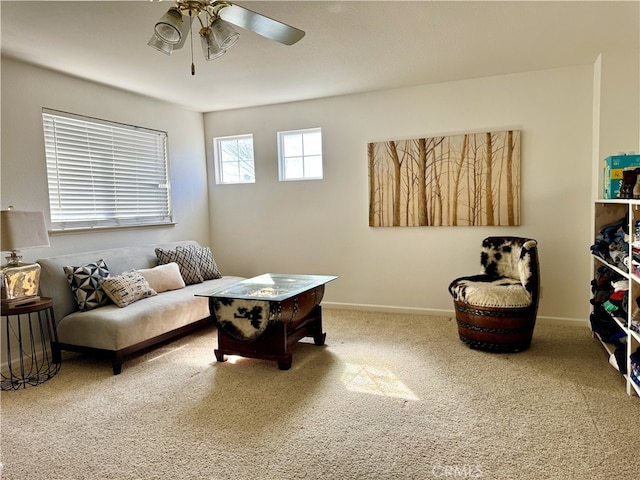 living area with carpet, a ceiling fan, and baseboards