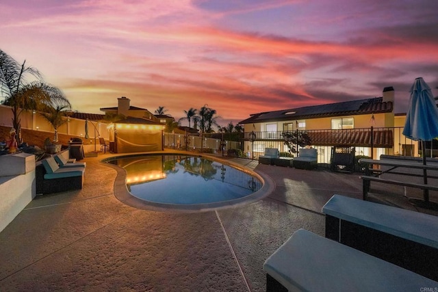 pool at dusk featuring a fenced in pool, a patio, and fence