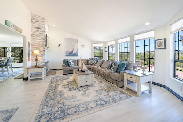 living room with a wealth of natural light, vaulted ceiling, light wood finished floors, and recessed lighting