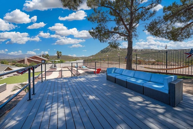 deck featuring outdoor lounge area, a mountain view, and fence