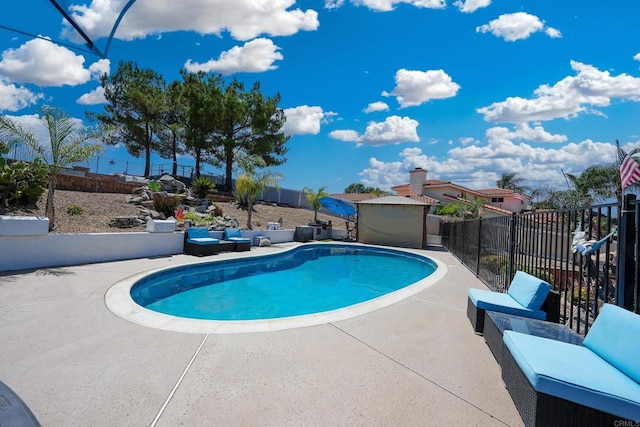 view of pool featuring an outdoor structure, a patio area, a fenced backyard, and a fenced in pool