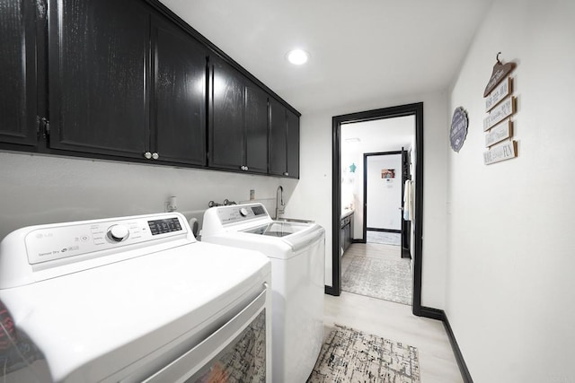 washroom with recessed lighting, cabinet space, a sink, independent washer and dryer, and baseboards