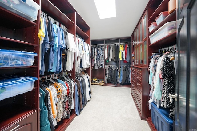 walk in closet featuring a skylight and light colored carpet