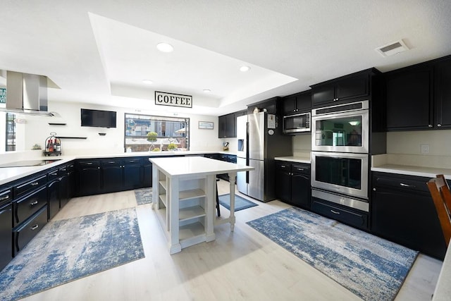 23767 Moonglow Ct, Ramona, CA 92065 - kitchen with wall chimney range hood, open shelves, dark cabinetry, a raised ceiling, and appliances with stainless steel finishes