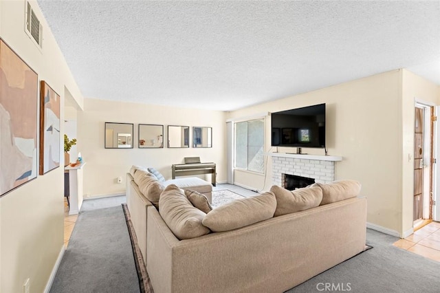 living room with a textured ceiling, light colored carpet, a fireplace, visible vents, and baseboards