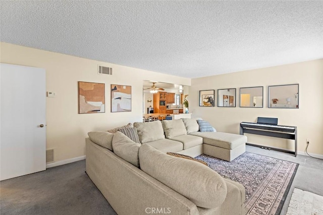 carpeted living room featuring baseboards, ceiling fan, visible vents, and a textured ceiling