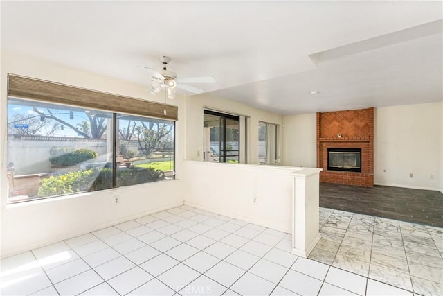 kitchen featuring a fireplace, baseboards, and ceiling fan