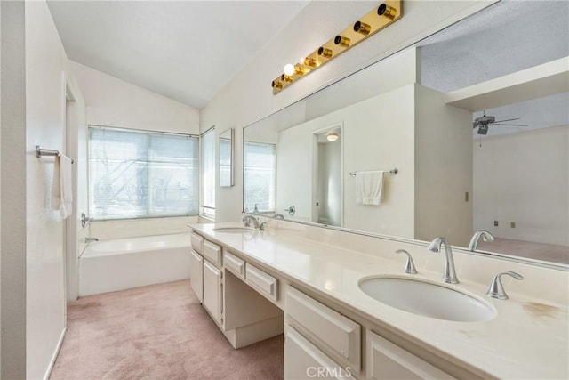 full bath featuring double vanity, a garden tub, vaulted ceiling, and a sink