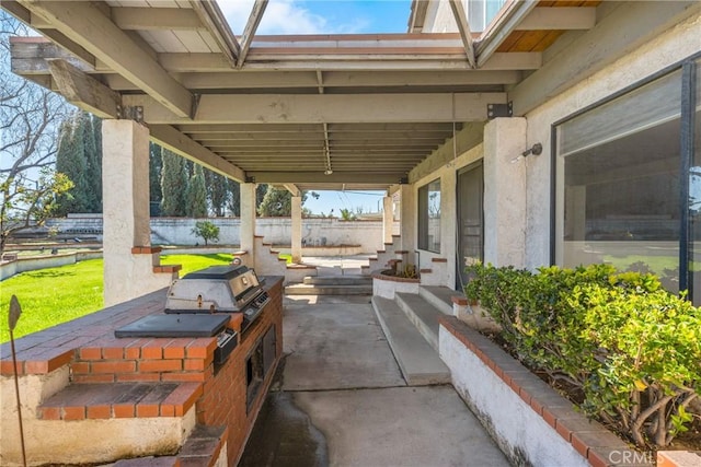 view of patio / terrace featuring fence, grilling area, and exterior kitchen