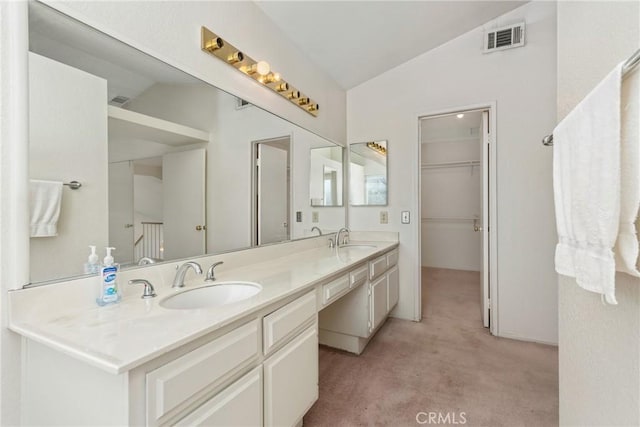 bathroom with lofted ceiling, double vanity, visible vents, and a sink