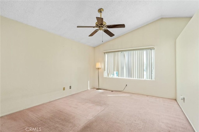 carpeted empty room with lofted ceiling, a textured ceiling, and a ceiling fan