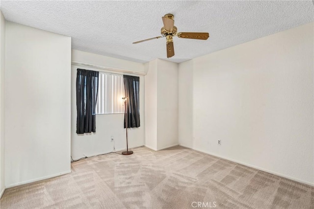 unfurnished room with carpet, ceiling fan, and a textured ceiling