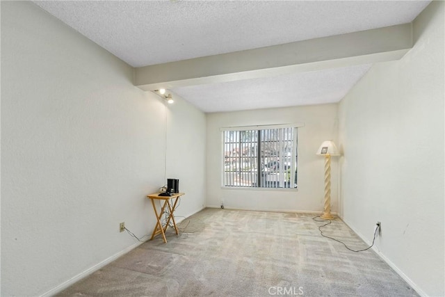 unfurnished room featuring carpet floors, baseboards, a textured ceiling, and beamed ceiling