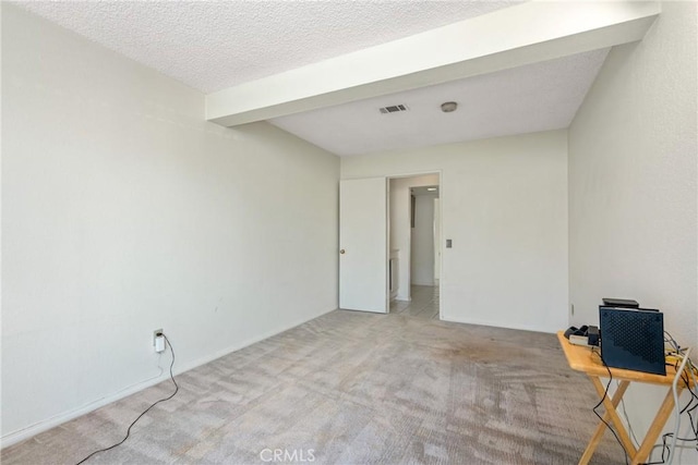 unfurnished room featuring carpet floors, visible vents, and a textured ceiling