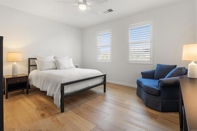 bedroom featuring light wood-type flooring, visible vents, baseboards, and ceiling fan