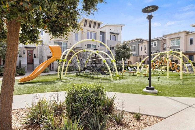 community playground featuring a residential view and a lawn