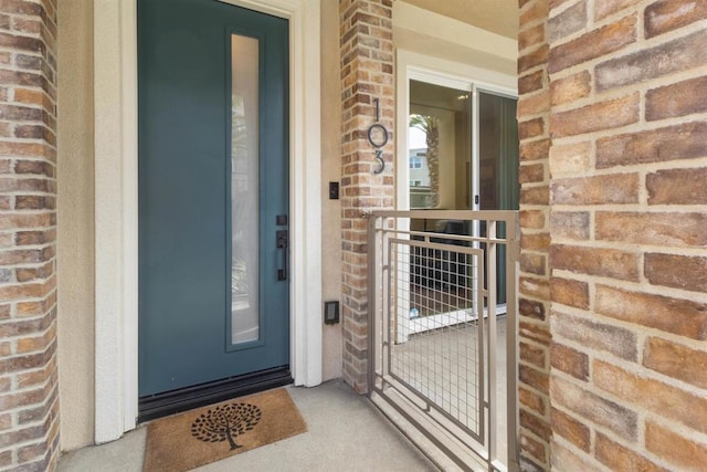 doorway to property with brick siding