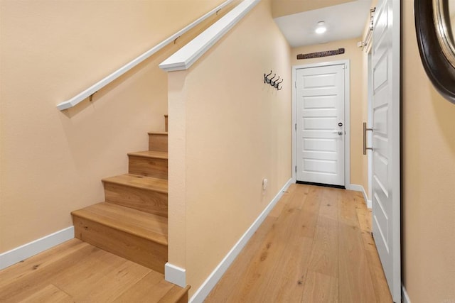 interior space with stairs, light wood-style floors, and baseboards