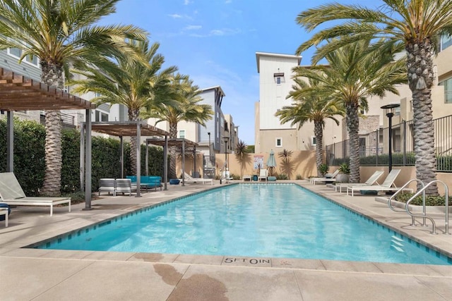 community pool featuring fence, a patio area, and a pergola