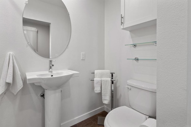 bathroom featuring toilet and baseboards