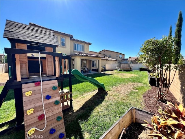 view of yard featuring a trampoline, a fenced backyard, and a playground